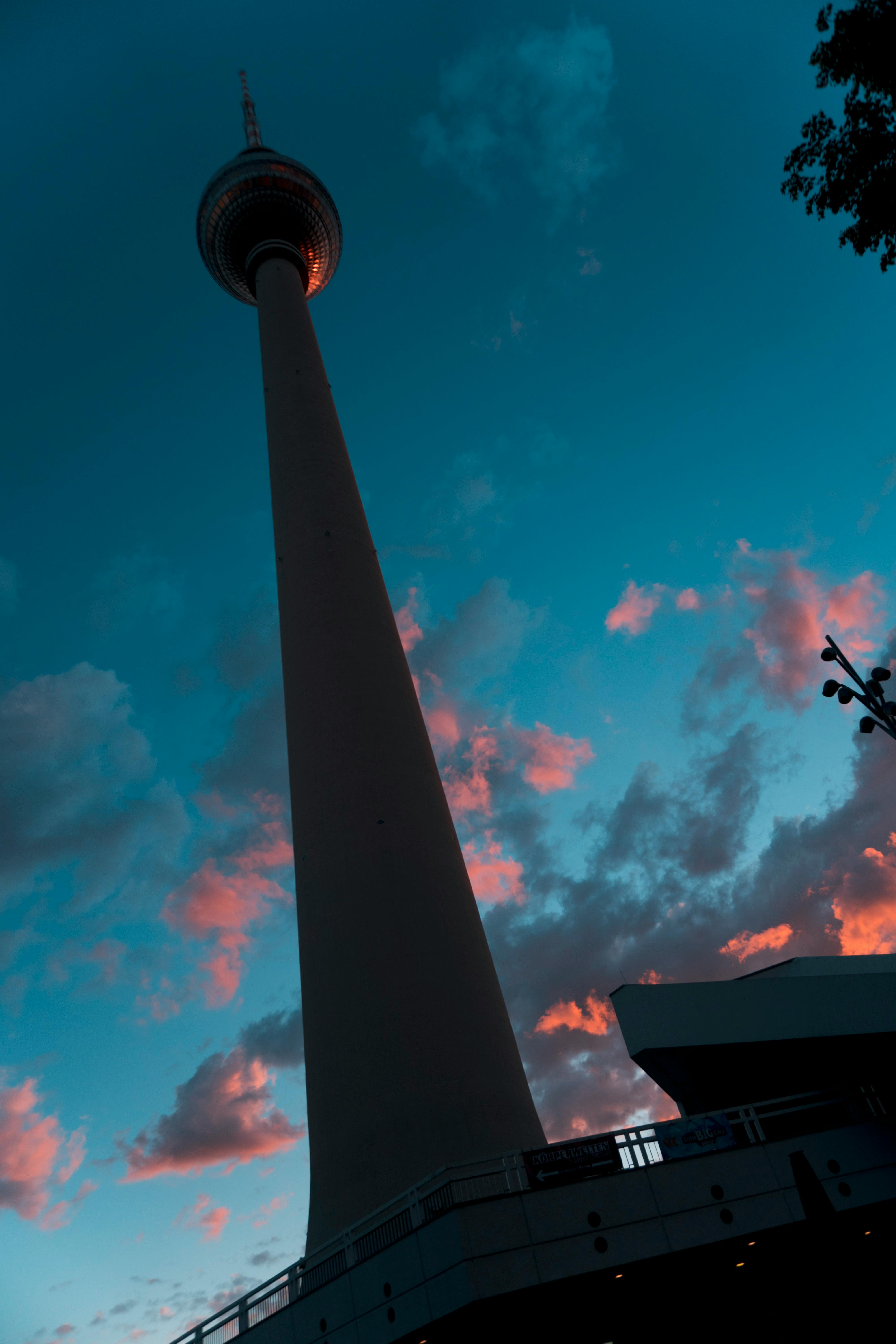 一座高塔的剪影，映衬在充满活力的戏剧性日落云层之下