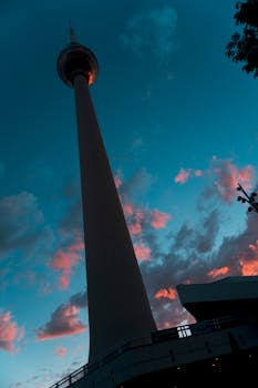 一座高塔的剪影，映衬在充满活力的戏剧性日落云层之下