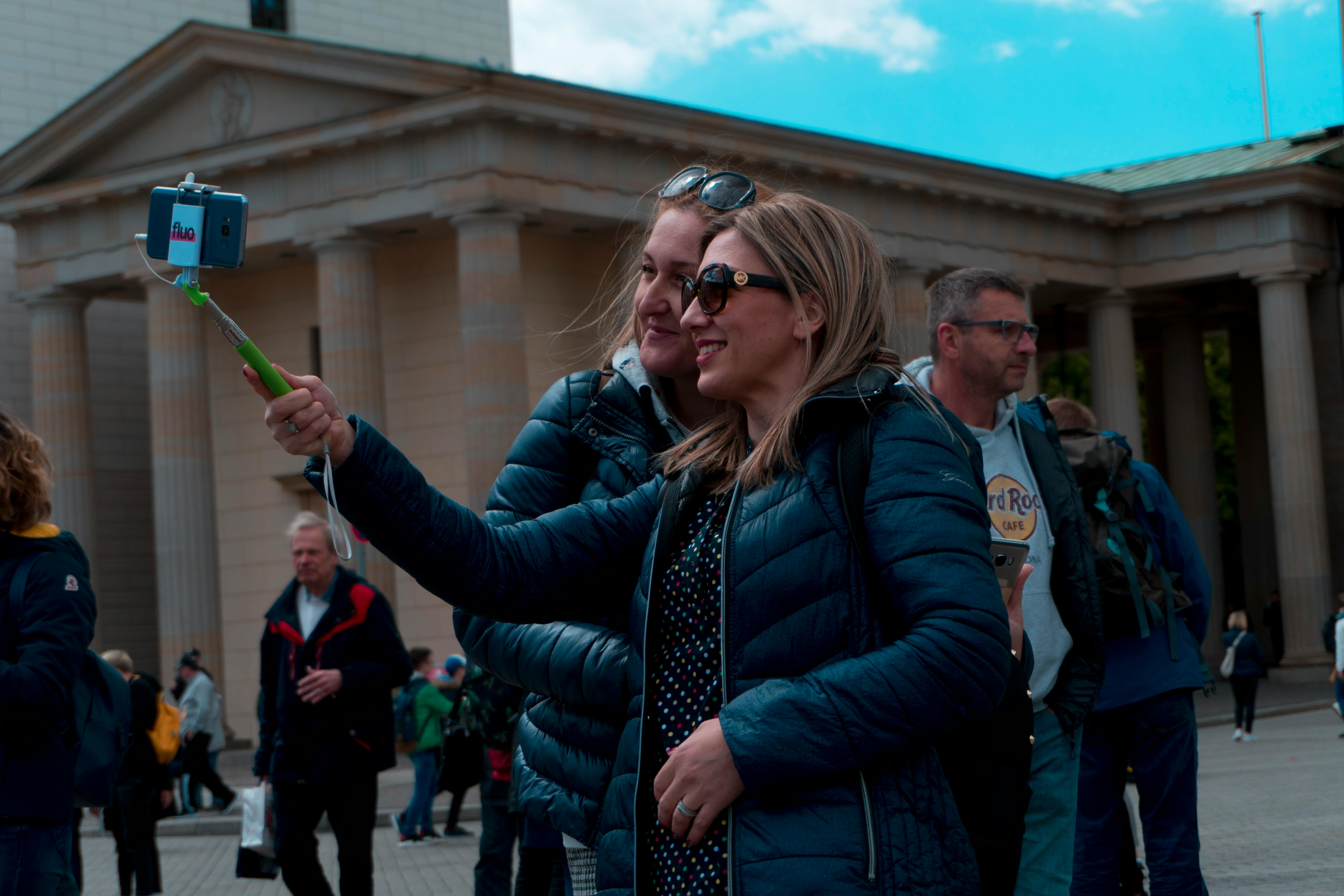 阳光明媚，妇女们在历史地标前自拍