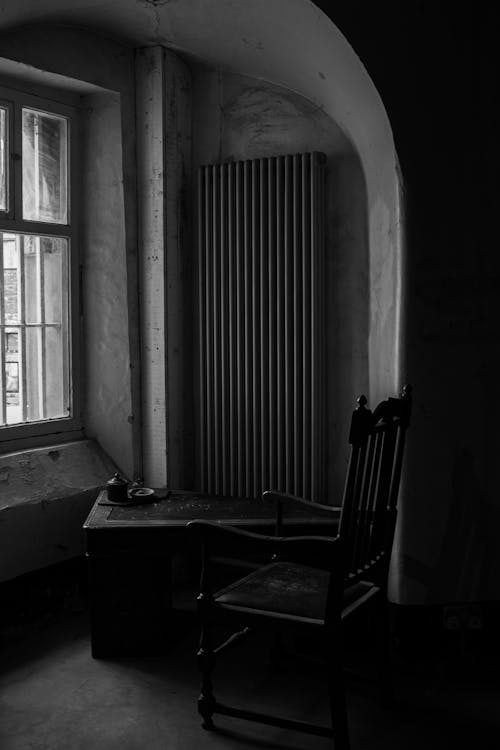 Фотография кресла возле окна в оттенках серого