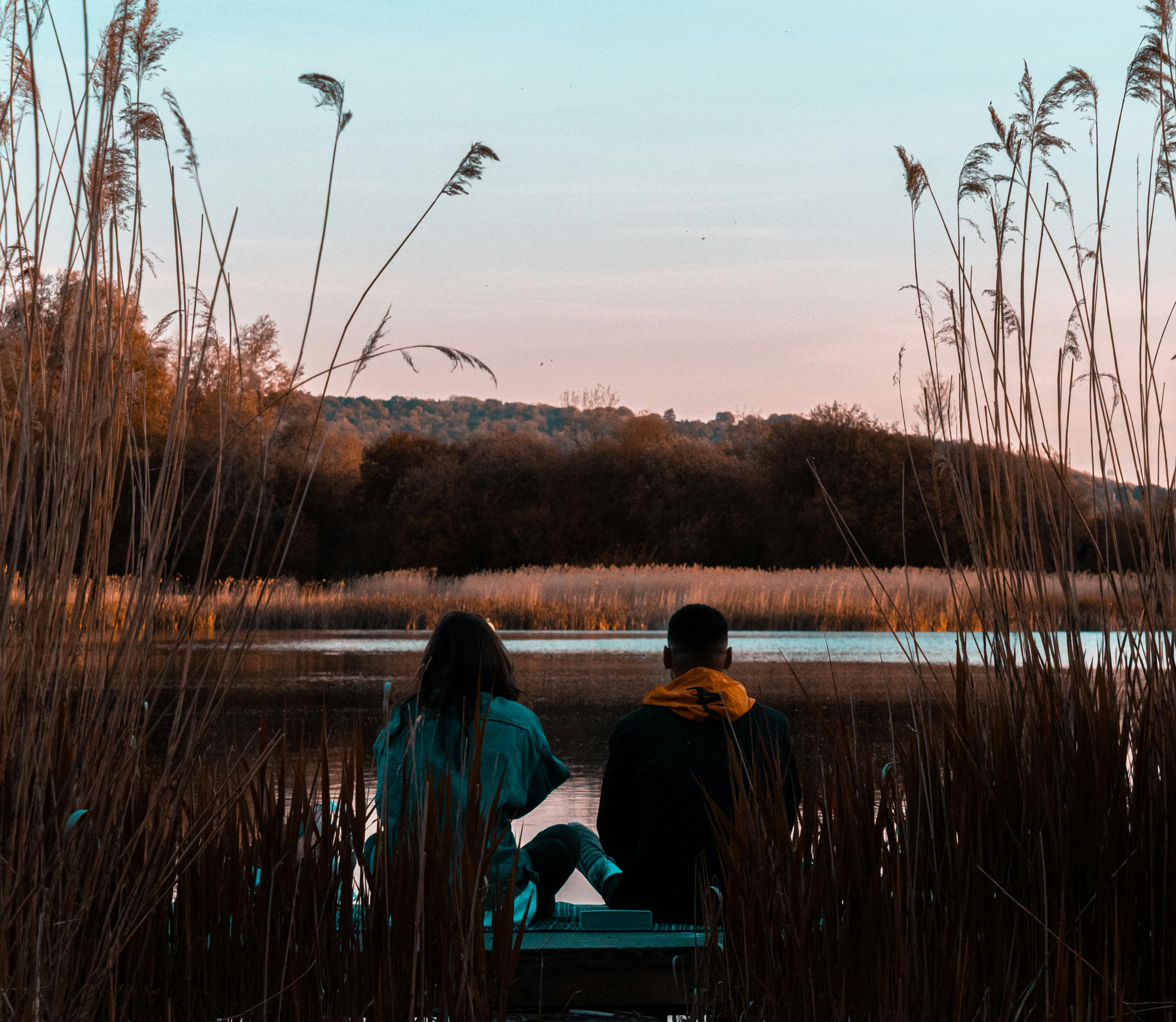 日落时分，一对夫妇在风景优美的湖边放松身心，四周环绕着宁静的秋色