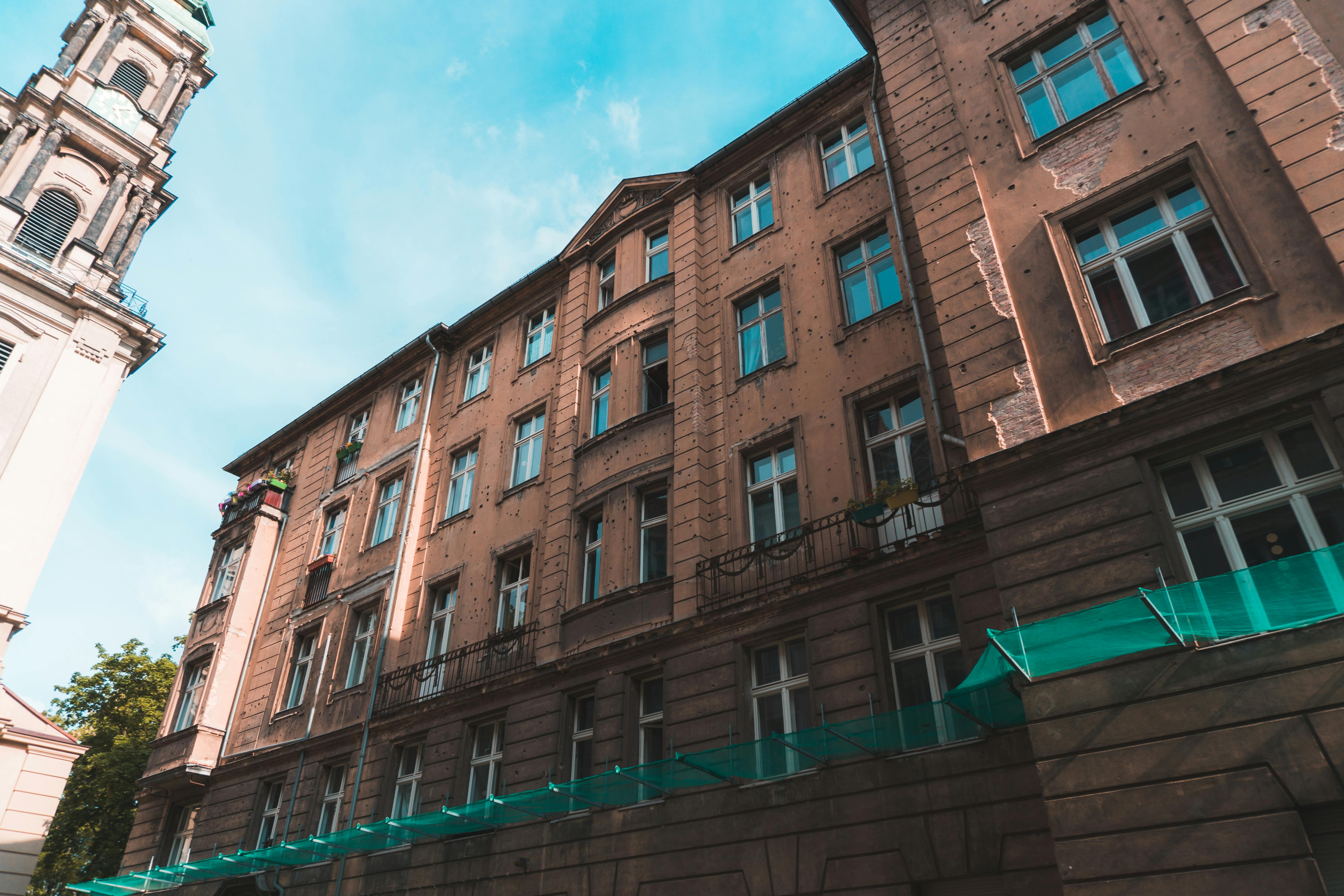 一座历史悠久的城市建筑立面，在明亮的天空下，以低角度镜头呈现