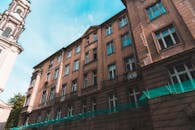 一座历史悠久的城市建筑立面，在明亮的天空下，以低角度镜头呈现