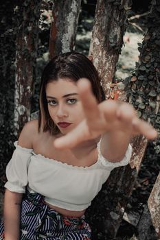 一位时尚女性在户外以自然为背景，对着相机摆姿势