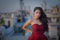 一位身着惊艳红裙的优雅女子，在屋顶上留下展现迷人风姿的肖像