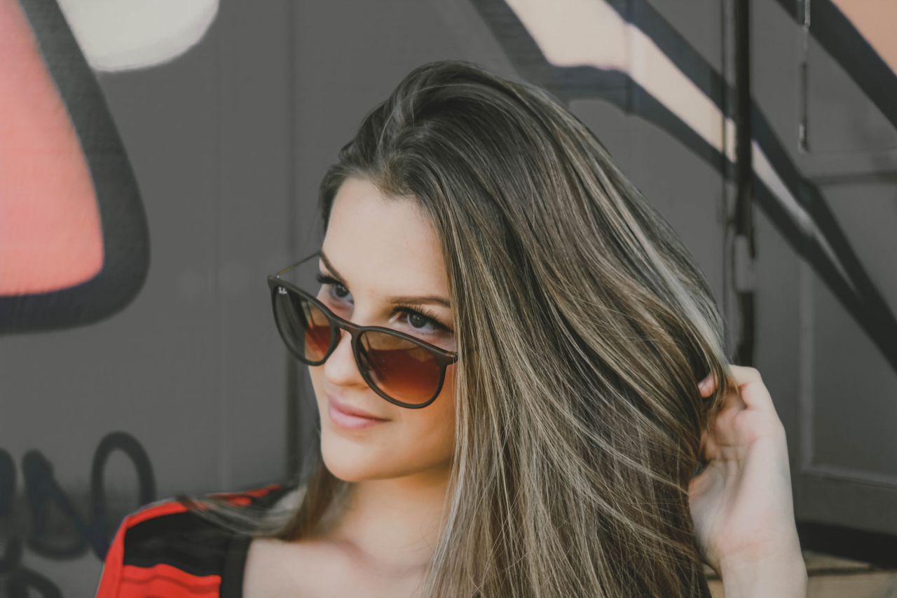 portrait of a fashionable woman in sunglasses against a graffiti wall