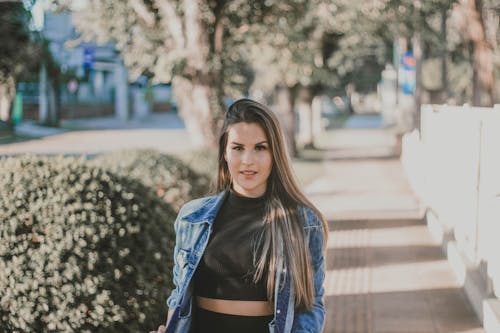 Free Photo of Woman in Black Cropped Top and Blue Denim Jacket Standing on Sidewalk Stock Photo