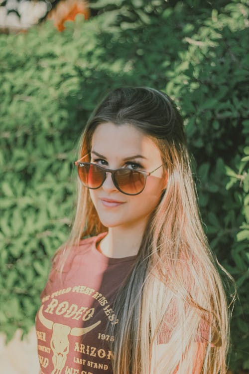 Free Photo Woman in Brown T-shirt and Sunglasses Standing In Front of Green-leafed Plants Stock Photo