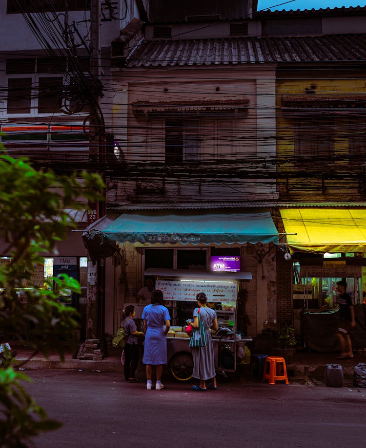 People Standing In Front Of Food Stall