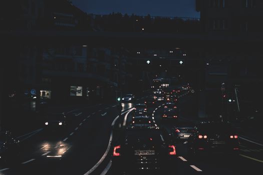 A bustling night scene with cars and city lights in Zürich, Switzerland, depicting urban traffic.