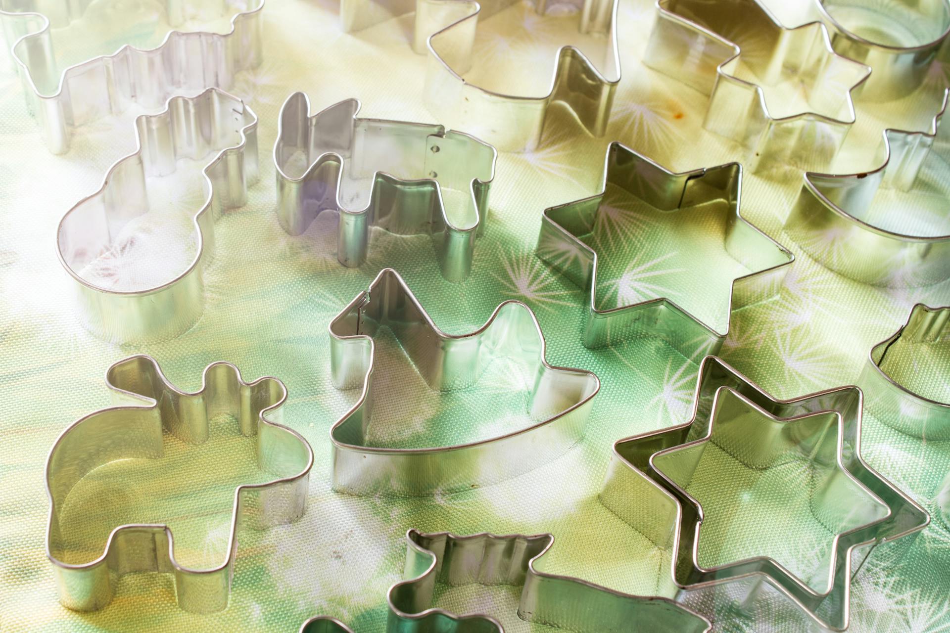 A collection of holiday-themed metal cookie cutters resting on a colorful surface.