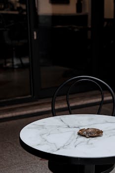 A stylish marble table with an ashtray inside a dimly lit restaurant interior.