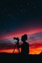 Silhouette of Woman Photographer Using Camera at Night