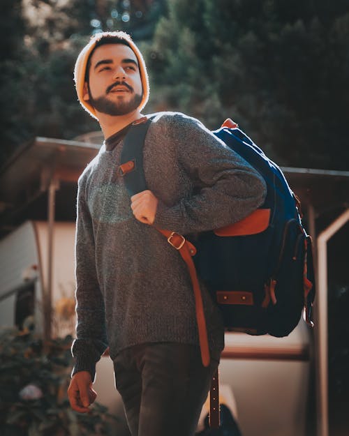 Free Photo of Man in Gray Swearer Standing Outside Carrying Blue and Brown Backpack Stock Photo