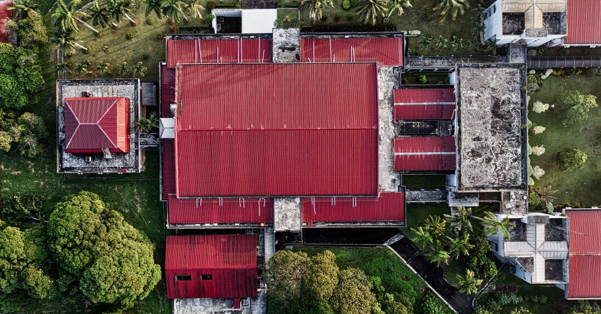 Aerial shot of red-roofed buildings surrounded by lush greenery in Tangerang, Indonesia.