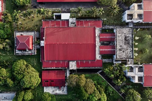 Free Aerial shot of red-roofed buildings surrounded by lush greenery in Tangerang, Indonesia. Stock Photo
