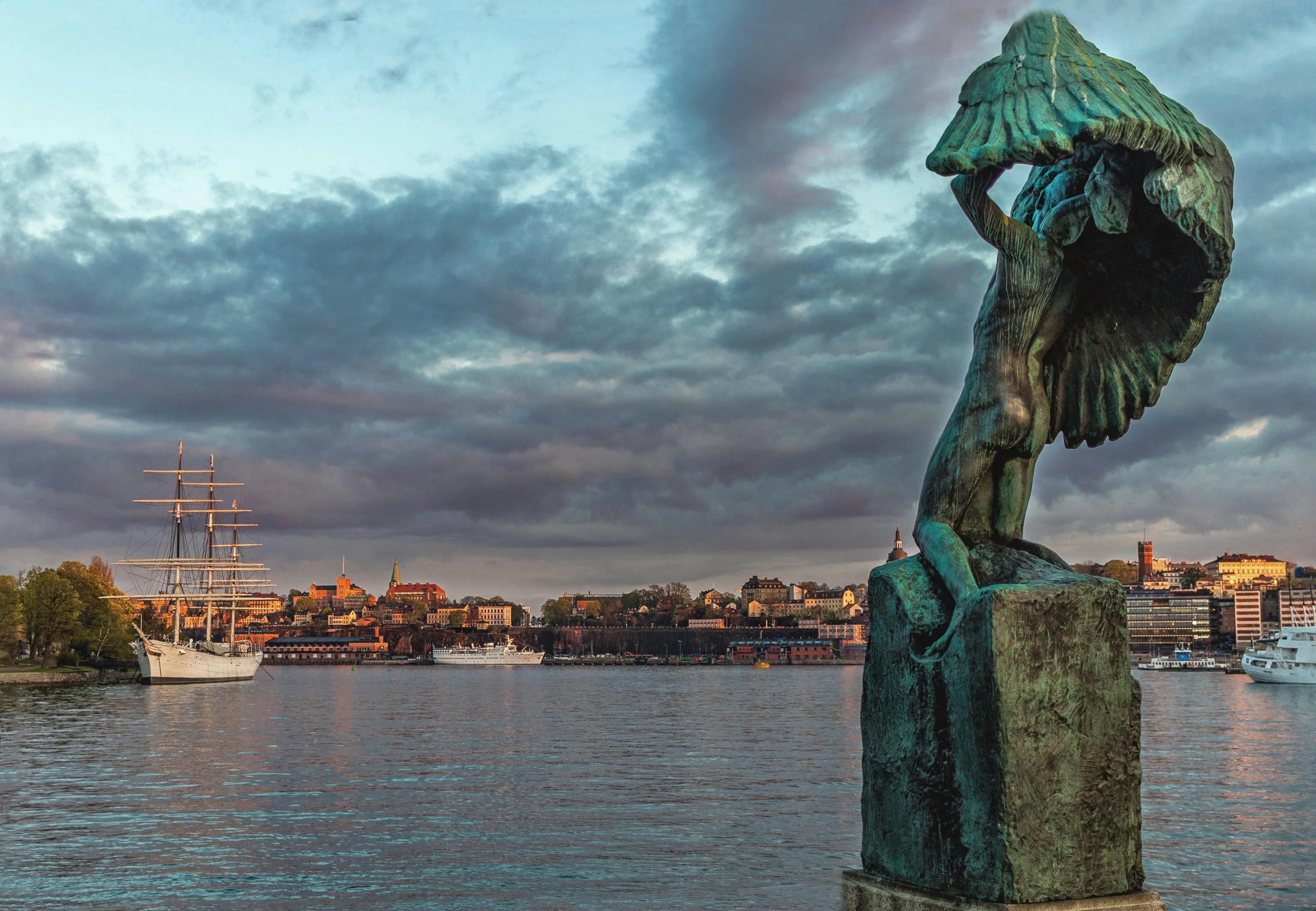 Statue Near Body of Water Under Cloudy Sky · Free Stock Photo