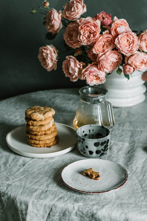 Free Pink Flowers Beside Plate of Biscuits Stock Photo