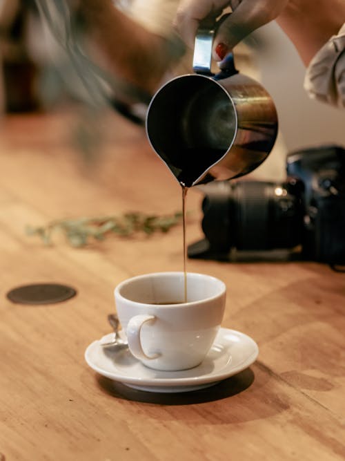 A person pouring coffee into a cup
