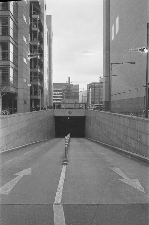 A black and white photo of a tunnel with a street