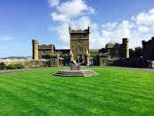 在明亮的蓝天下，苏格兰南艾尔郡的库尔济恩城堡被郁郁葱葱的绿色花园所环绕