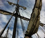 帆船桅杆的特写镜头中，绳索和帆映衬着蓝天