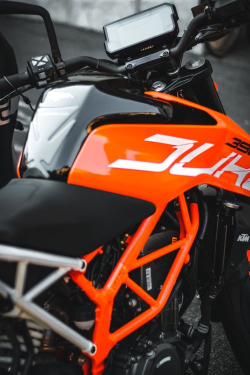 Free Close-up of a modern orange motorcycle showcasing its sleek design and vibrant color. Stock Photo