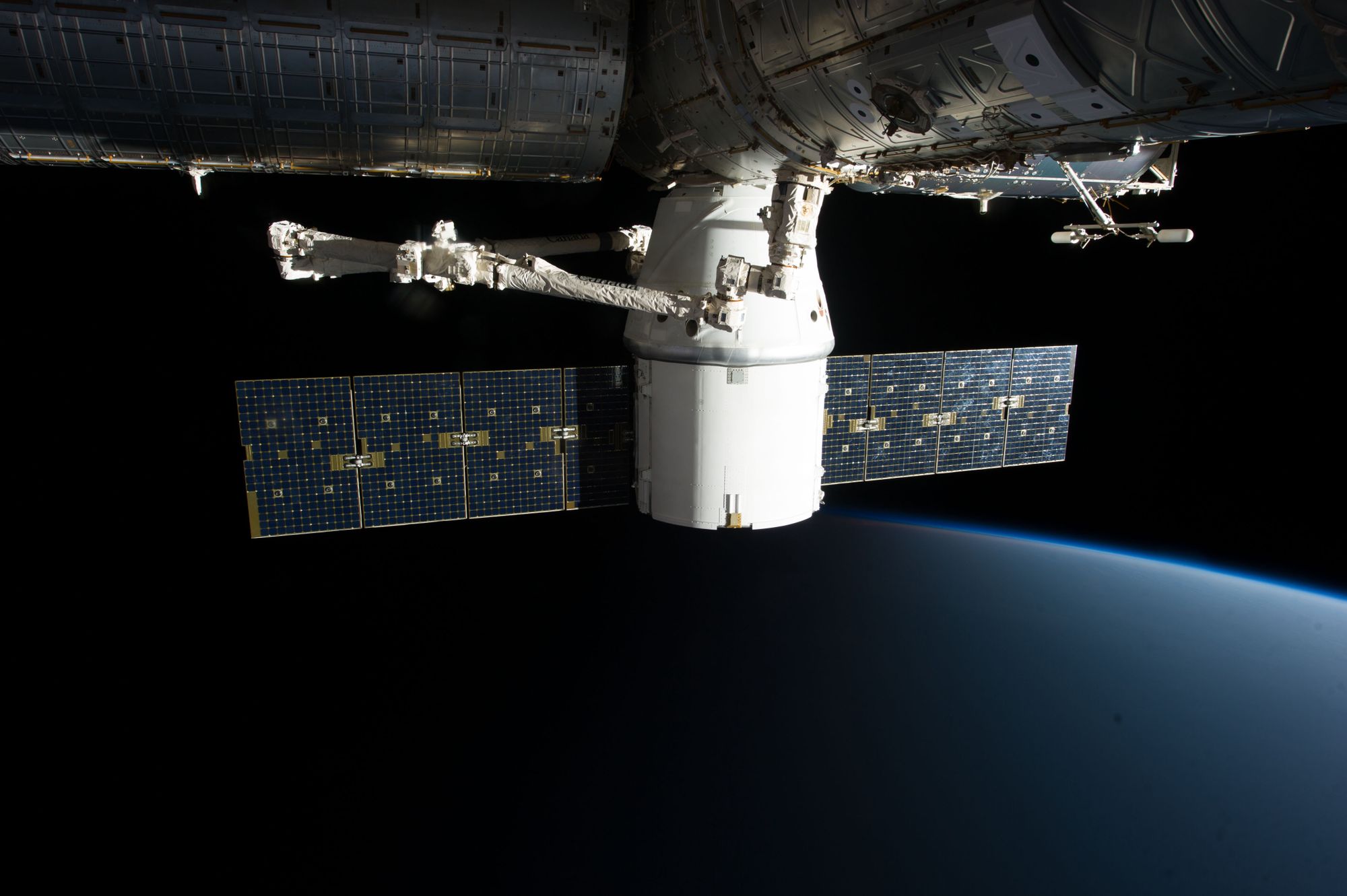 Panel solar de un satélite desplegado sobre el fondo de la Tierra vista desde la órbita baja