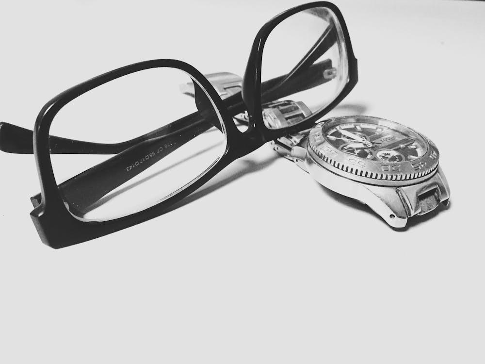Grayscale Photography of Black Framed Eyeglasses on Watch