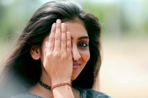 Woman in Black Shirt Wearing Gold Bracelet Covering Her Face
