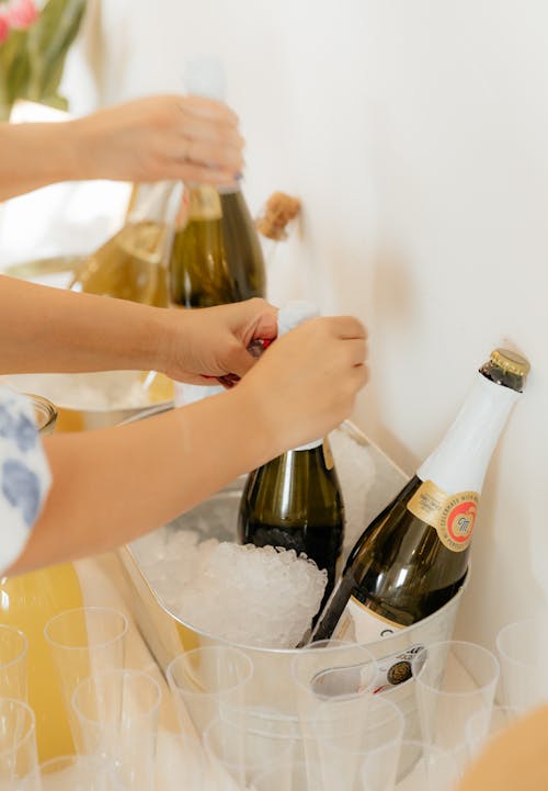 A woman pouring champagne into a bucket