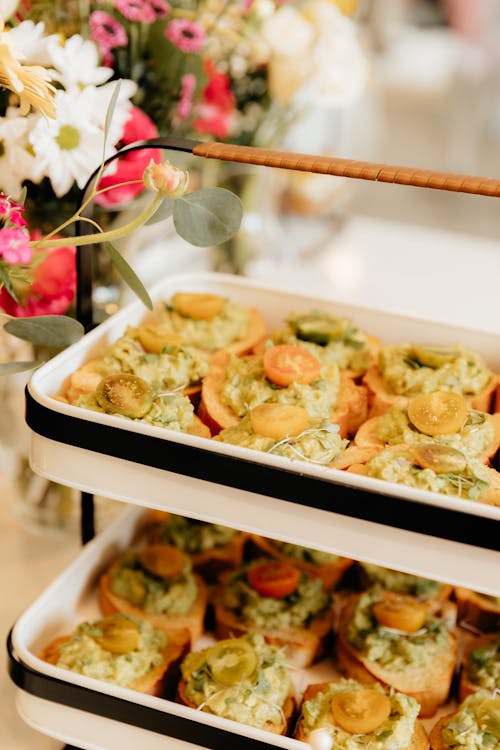 A tray of appetizers with green and yellow flowers