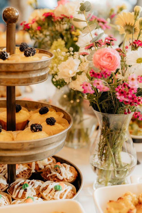A table with a variety of desserts and flowers
