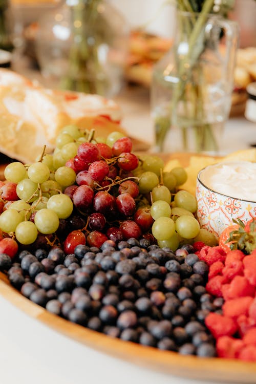 A platter of fruit and cheese is on a table