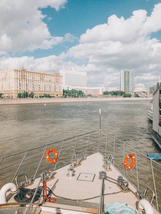 White Boat on Body of Water Near Buildings