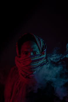 一名戴着条纹头巾的男子被彩色烟雾环绕，形成一幅空灵的肖像
