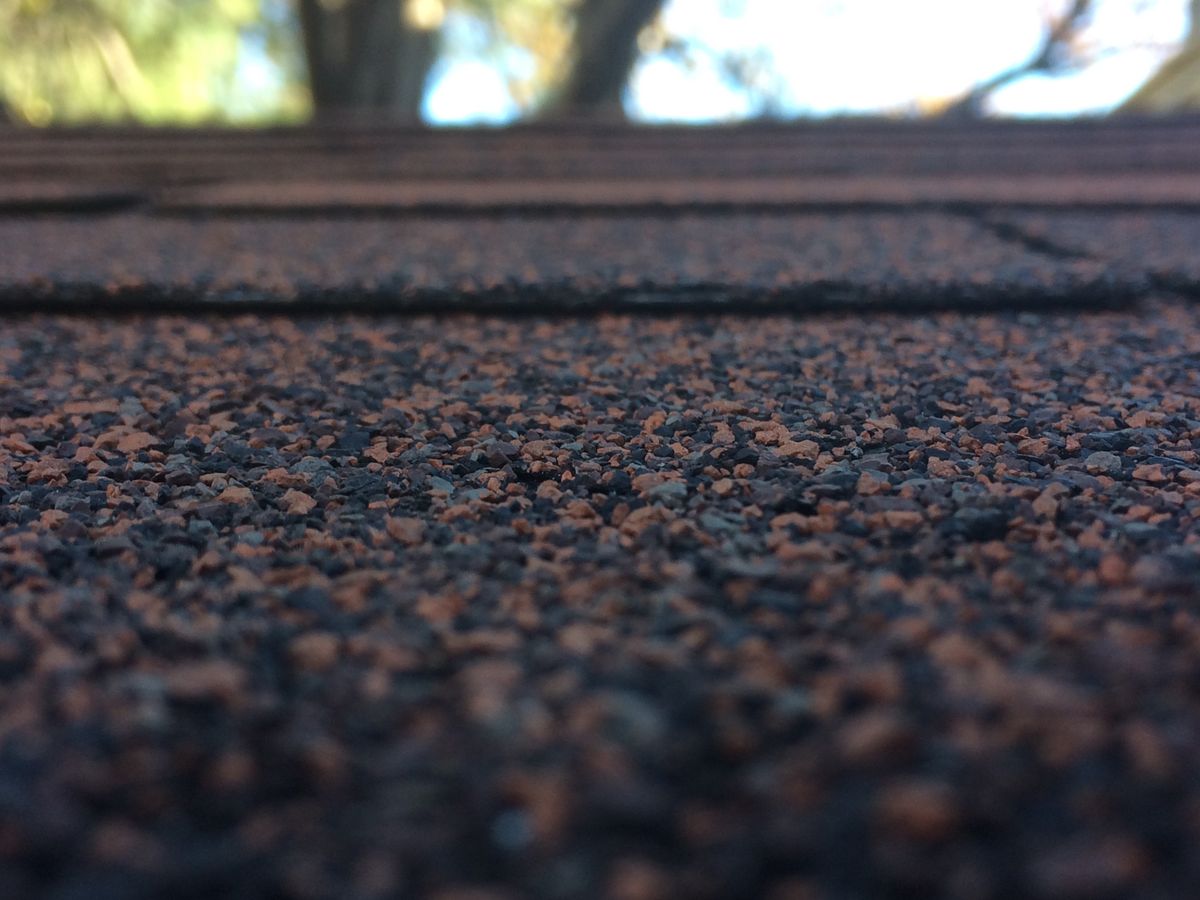 Close-up of roof shingles showcasing texture and depth of field, the material priced by the square