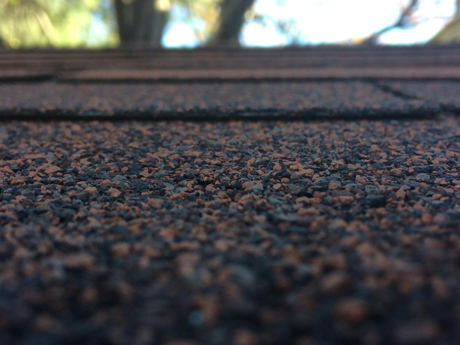 Artistic close-up of roof shingles showcasing texture and depth of field with bokeh background.