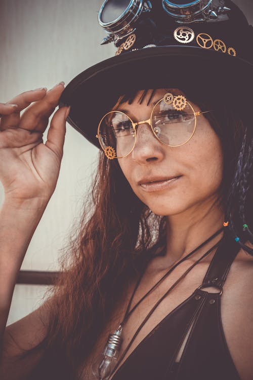 Close-up Portrait Photo of Woman In Eyeglasses Tipping Black Top Hat