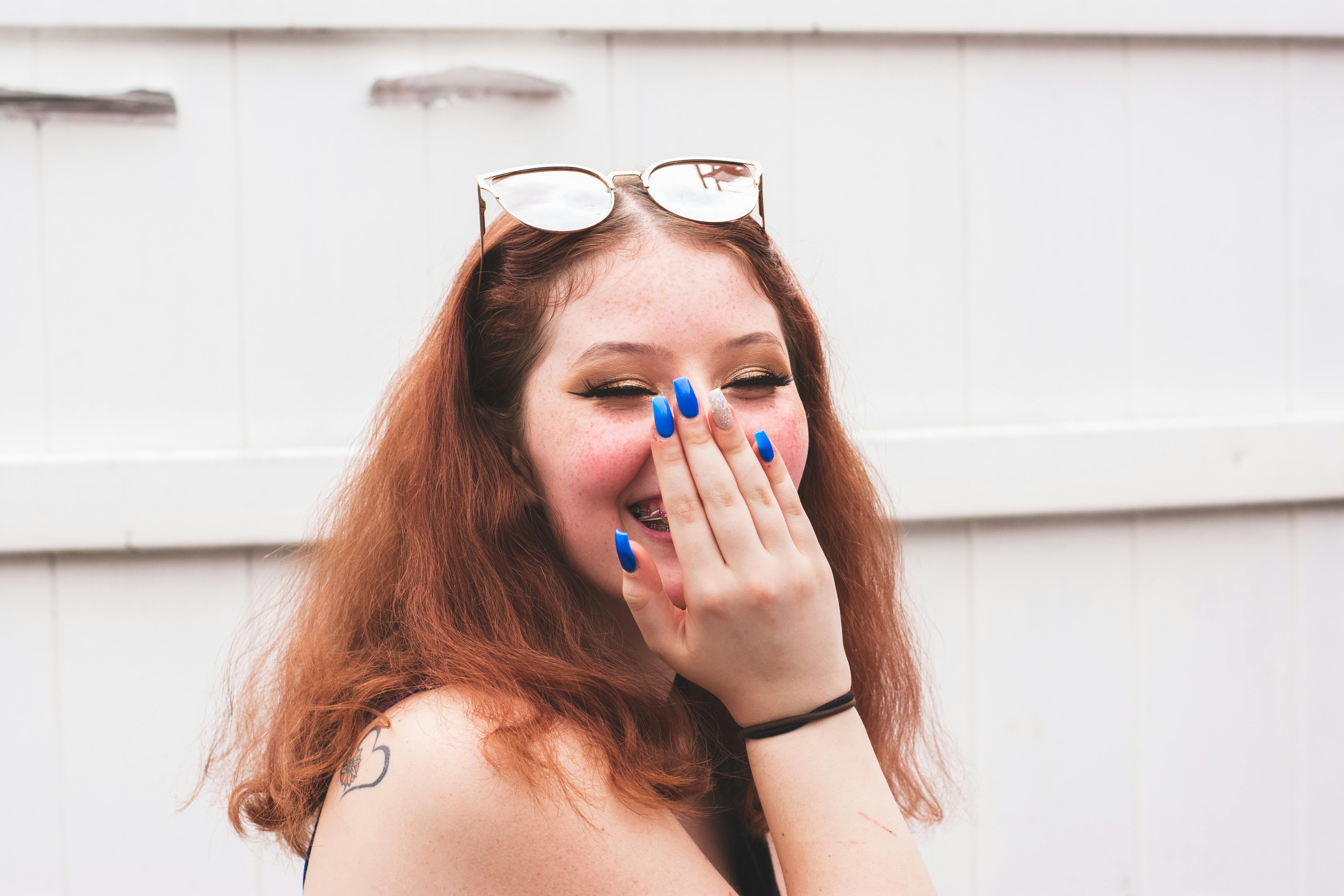Portrait Photo of Woman Hiding Her Laugh With Her Hand
