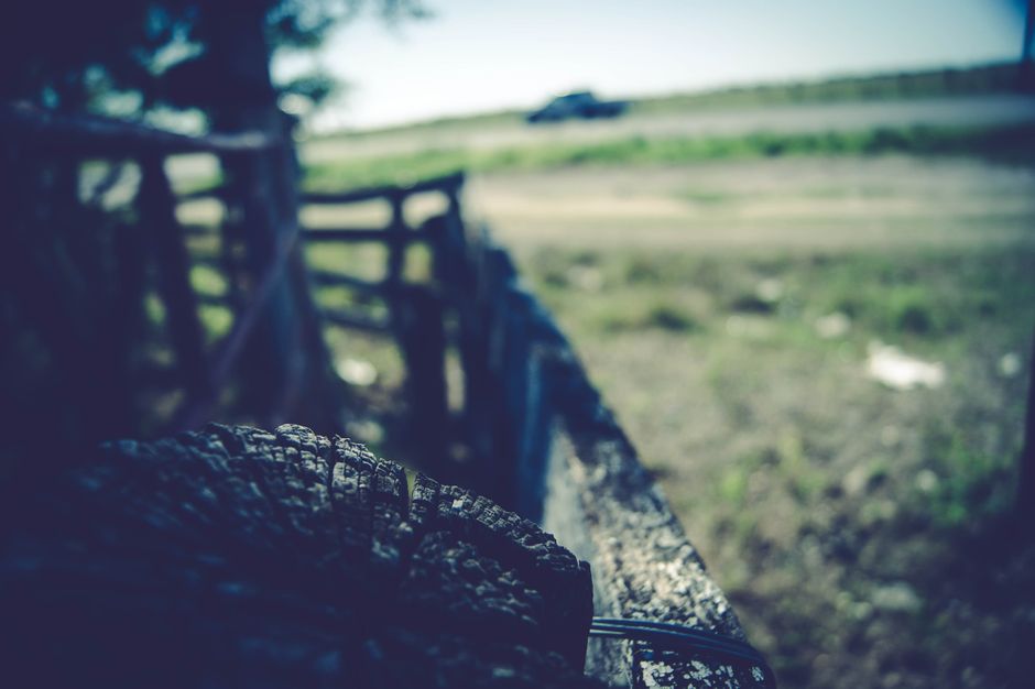 Capture of a rustic ranch landscape with a blurred truck speeding by.