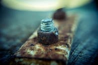 Selective Focus Photography of Brown Steel Knot on Brown Metal Plate