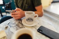 一个人在巴拿马咖啡馆享用咖啡，用着智能手机