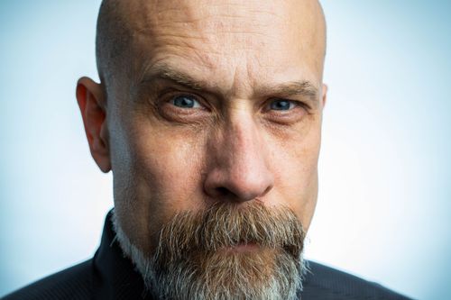 Free Close-up portrait of a serious, bald man with a beard and blue eyes. Stock Photo