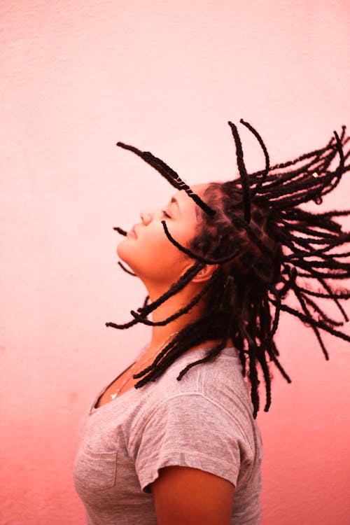 Woman in Gray Shirt Flipping Her Braided Hair and Looking Up