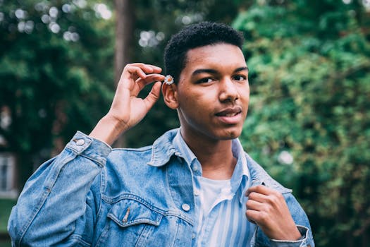 一个穿着牛仔夹克的年轻人在户外自然环境中手持雏菊的休闲肖像