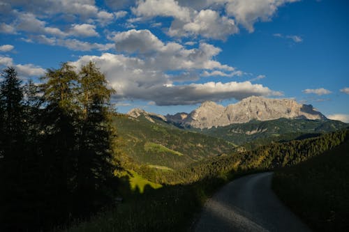 A road leading to the mountains with a blue sky