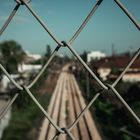 A chain-link fence looking out over railway tracks — photo by Damien Daye on Pexels