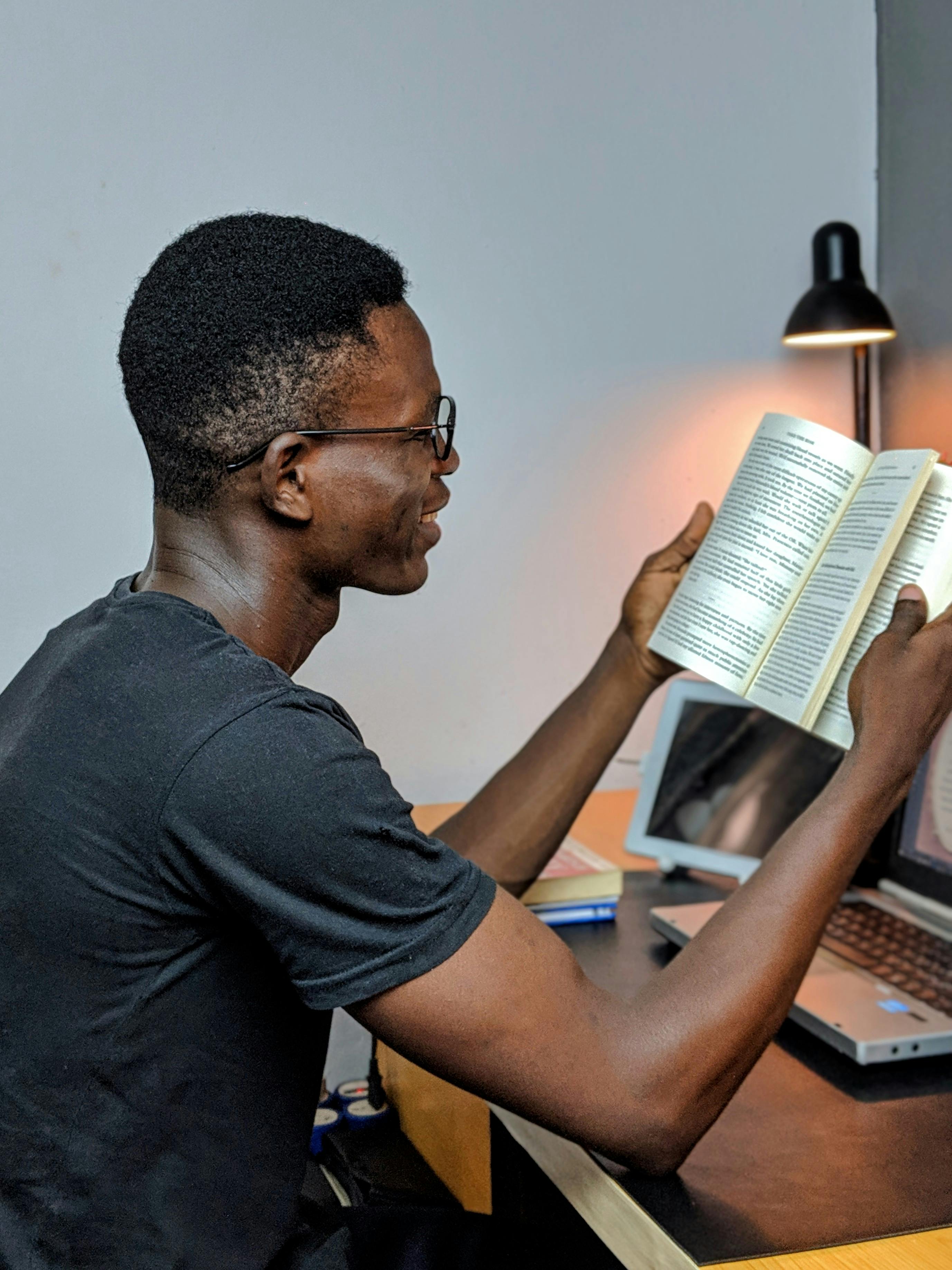 Man Wearing Gray Crew-neck Shirt Holding Book