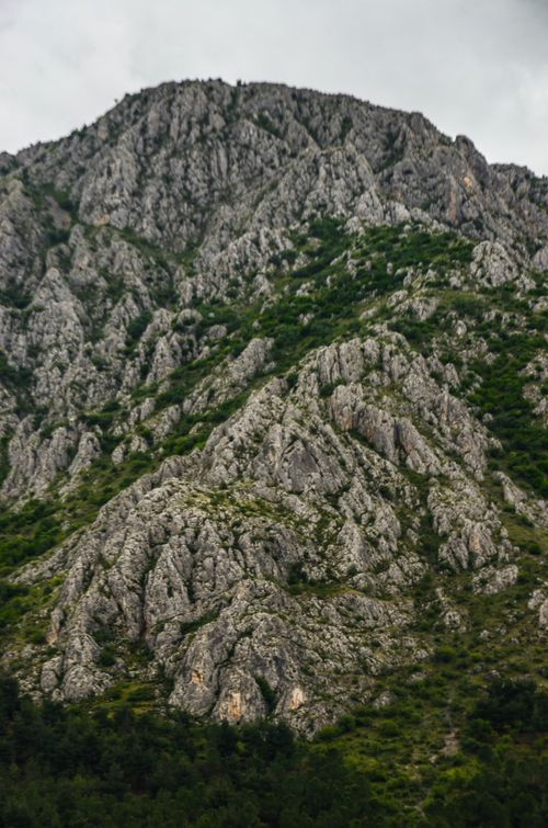 Free Captivating mountainous terrain showcasing rugged rocks and verdant greenery creating a stunning wilderness scene. Stock Photo